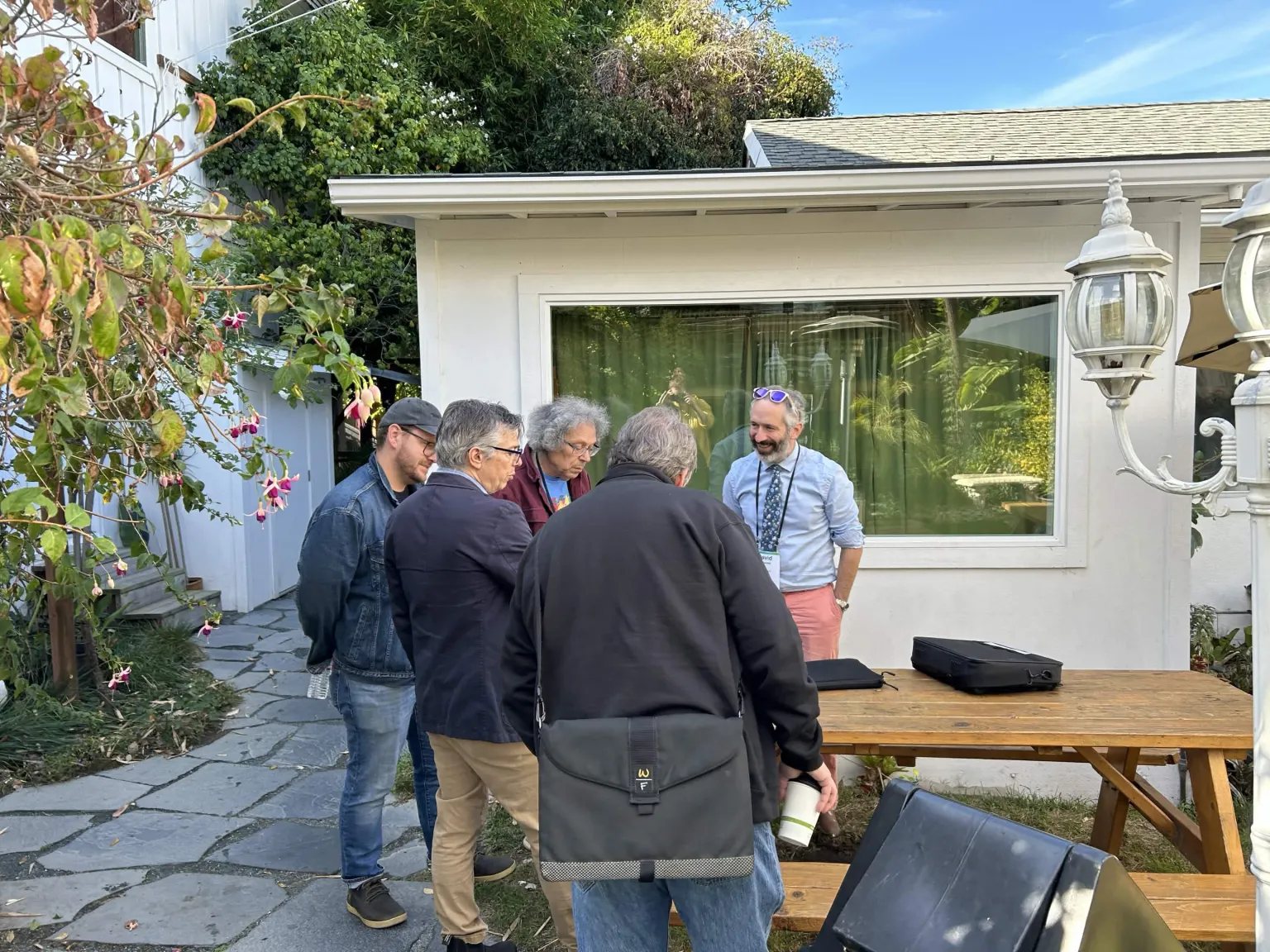 Campers talking in a small group outside a cottage at Lighthaven